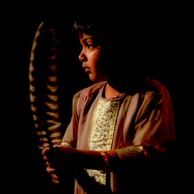 Indian girl holding hawk feather photographed by David Lee Black. 