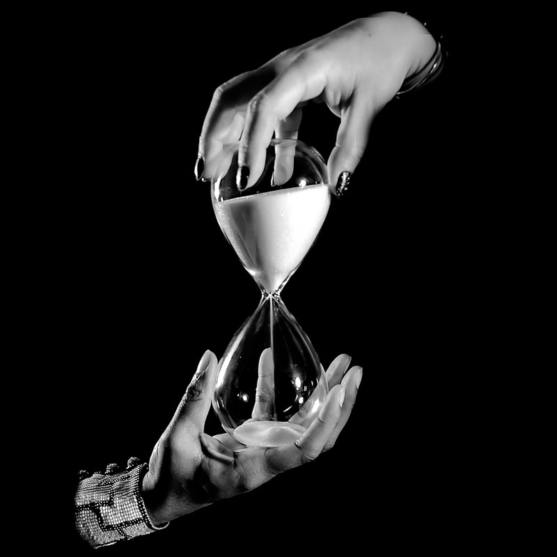 Noted Boston fine art photographer David Lee Black photographs surrealism hands with hourglass symbolizing time. 