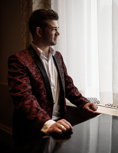 Fine Art photographer David Lee Black portrait of pianist Nick Sanfilippo next to grand piano of Biltmore Hotel, Providence, Rhode Island. Red smoking jacket looking out window. 
