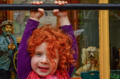 fine art photographer David Lee Black with red hair irish lass hangin from bar in Ennistimon, County Clare, Ireland. 